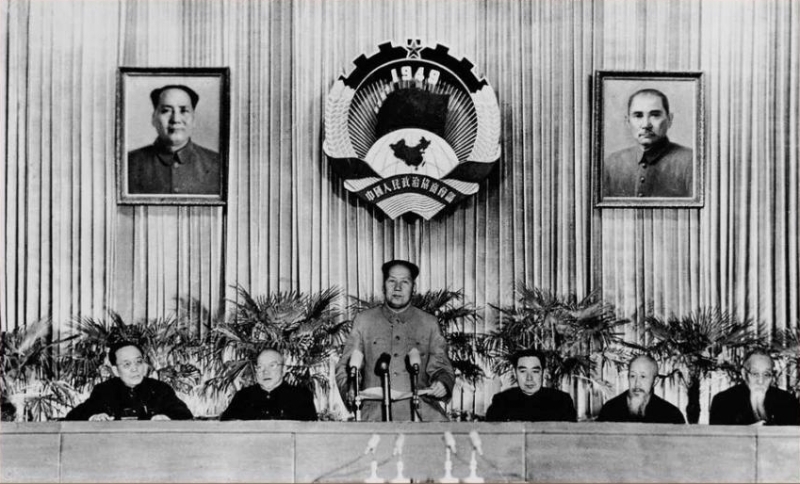 50年代的政協(xié)會議，主席臺上有政協(xié)會徽，還有毛澤東和孫中山的畫像。