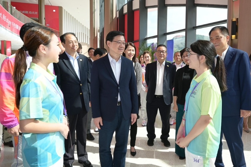 李家超（左三）與杭州第19屆亞洲運動會志愿者交流。 政府新聞處