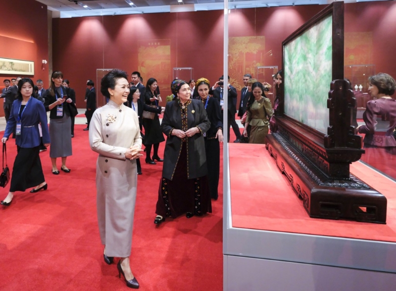 彭麗媛同外方領(lǐng)導(dǎo)人夫人參觀展品。