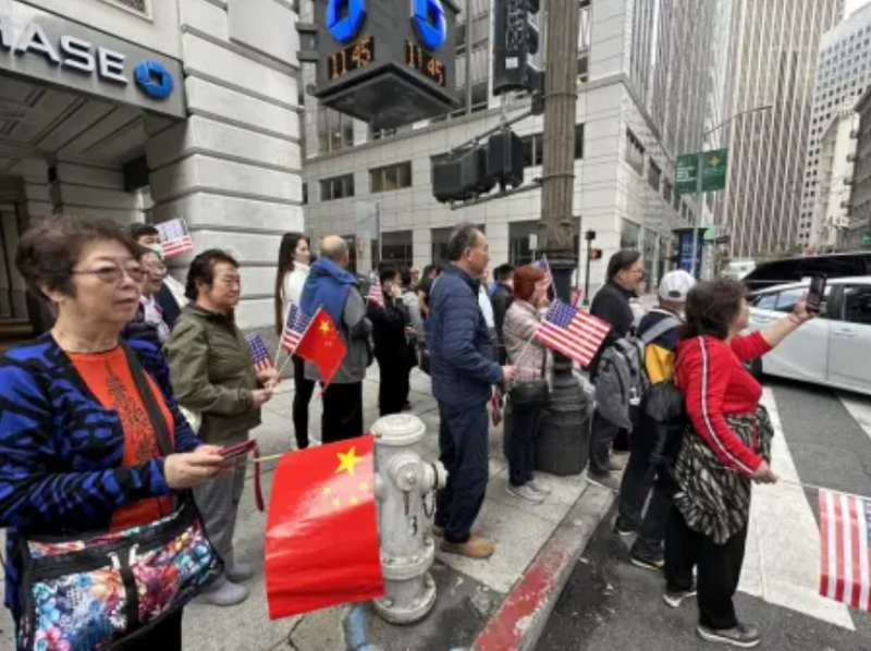 大批華裔居民手持中國國旗和美國國旗一同從華埠康年海鮮酒家步行往市場(chǎng)街，準(zhǔn)備迎接習(xí)近平主席。