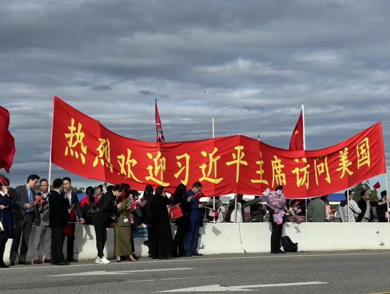 僑胞機(jī)場(chǎng)揮五星紅旗，迎接習(xí)近平主席