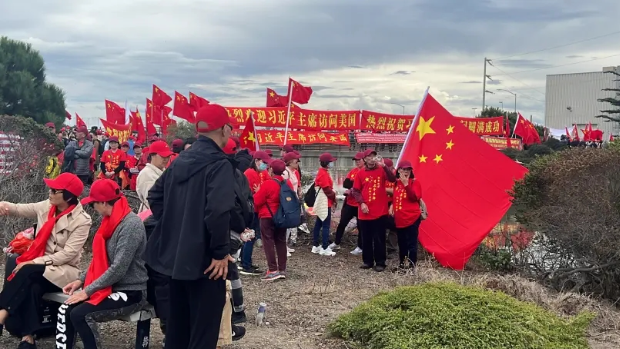 ▲大批僑胞在舊金山國(guó)際機(jī)場(chǎng)外的海傍揮舞五星紅旗，準(zhǔn)備歡送習(xí)近平主席。