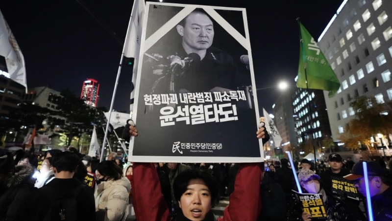 示威民眾高舉“推翻叛亂罪犯尹錫悅”的抗議海報。