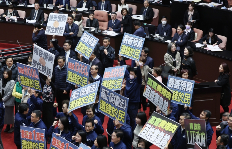 國(guó)民黨“立委”手持“嚴(yán)審預(yù)算，還錢于民”等標(biāo)語(yǔ)抗議。