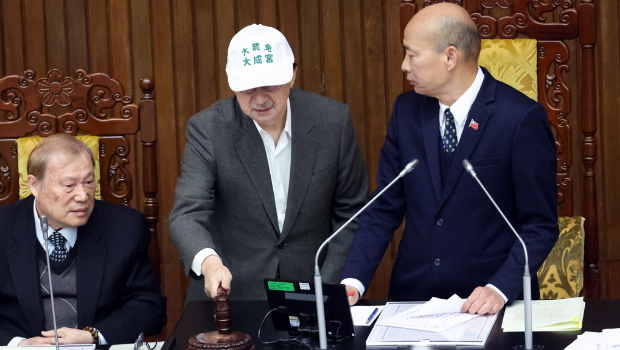 柯建銘（中）甚至上到主席臺(tái)，當(dāng)著韓國(guó)瑜（右）的面拿起木槌敲擊