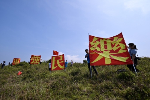 有市民于玉桂山頂上舉起自制的“軍強民樂”旗幟，表示是回應山東艦進港時甲板上的“國安家好”字句 。