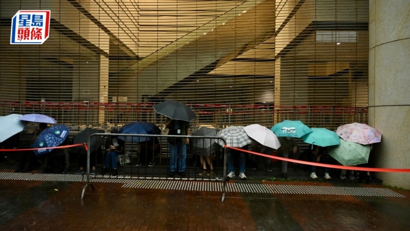 有近百名市民排隊，躲在法院外有瓦遮頭處。