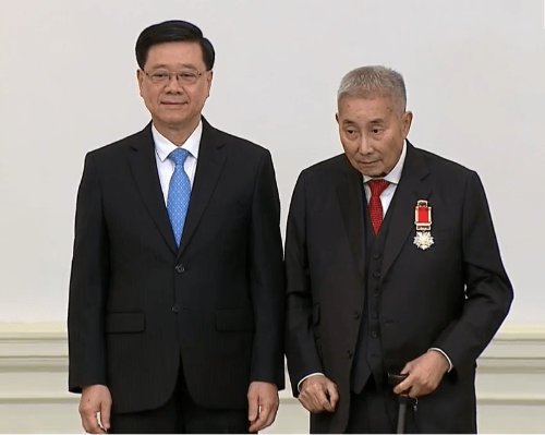 李家超向梁智仁頒發(fā)大紫荊勛章。